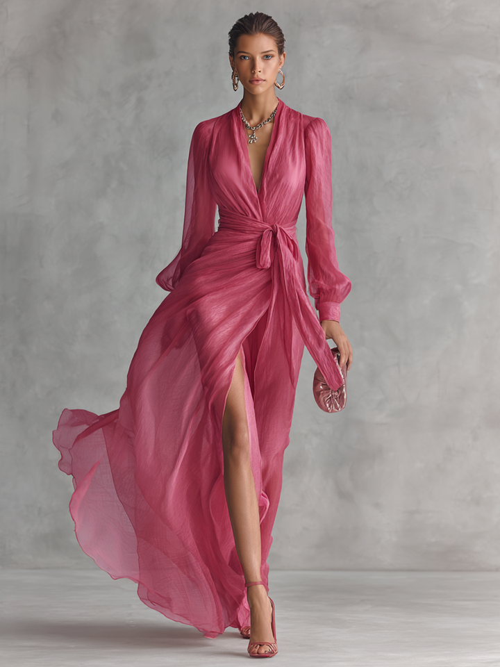 Women's pink maxi dress with wrap-design V-neck and long sheer sleeves, full body shot.