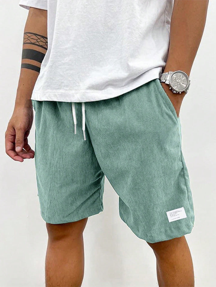 Men light green corduroy drawstring shorts with side pocket detail on model