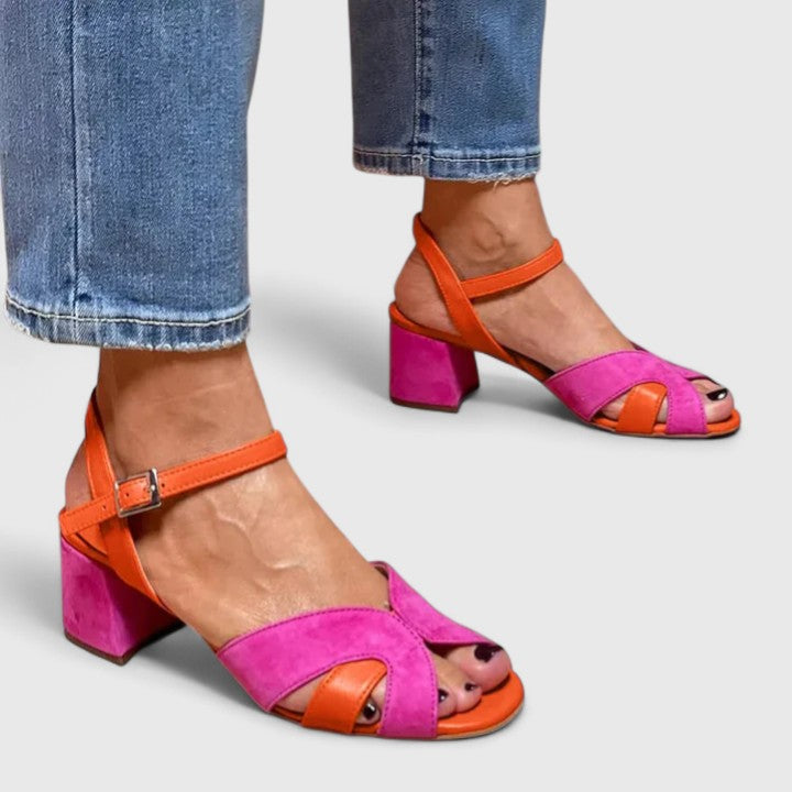 Women pink and orange block heel sandals with ankle strap, side view on foot