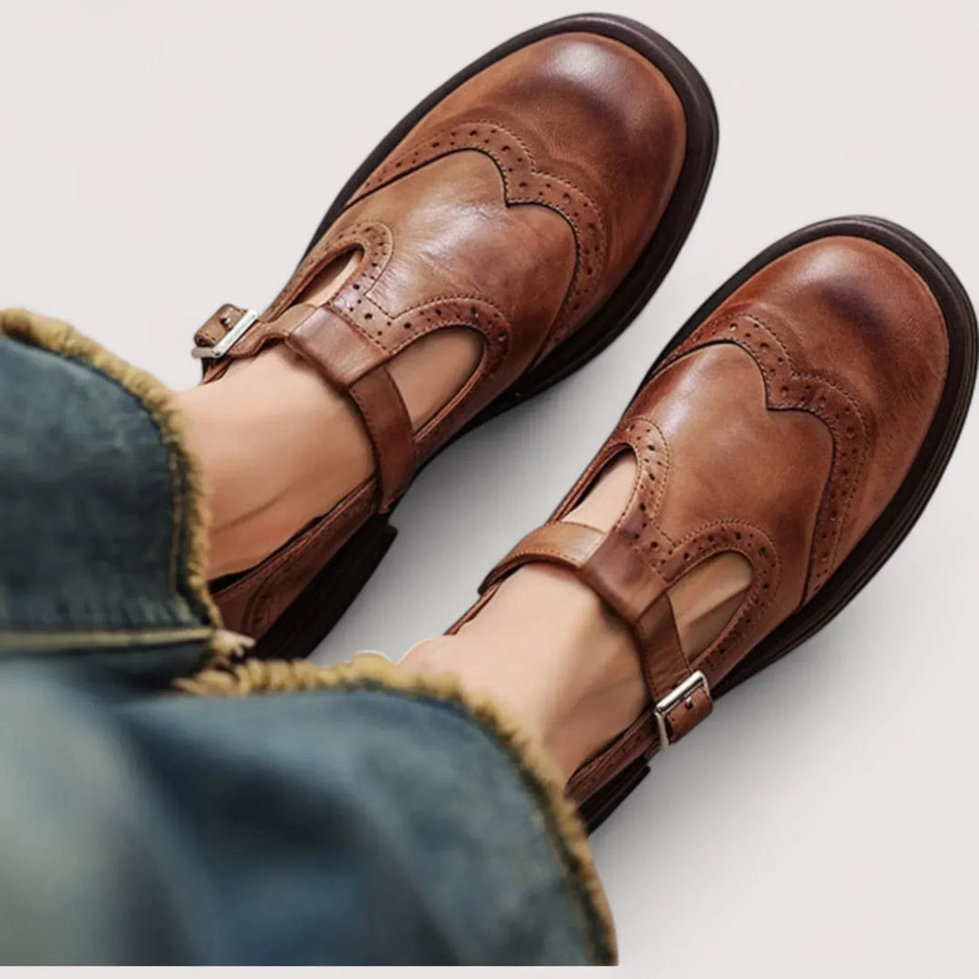 Women brown casual buckle Mary Jane shoes on feet with jeans, showing brogue detailing