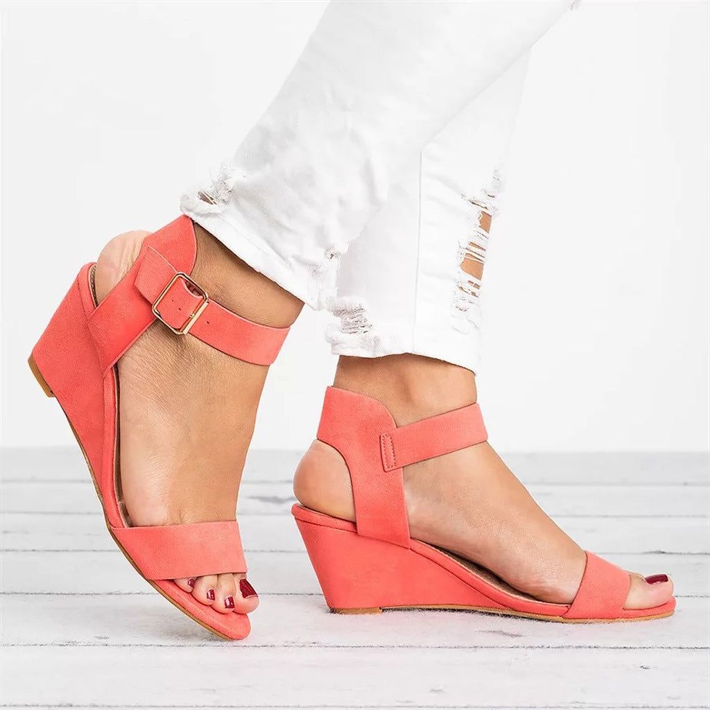 Women coral open toe wedge sandals with ankle strap and visible buckle detail on a model's foot.