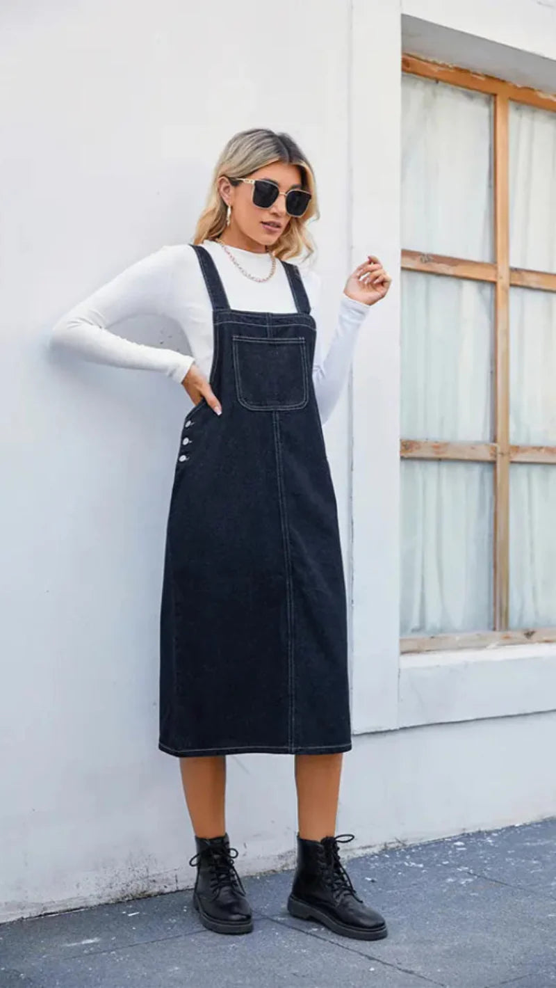 Women dark blue denim pinafore midi dress, front view showing chest pocket and side buttons