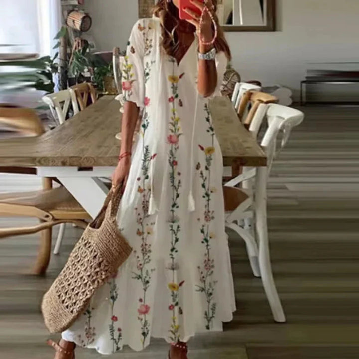 Women's white floral print maxi dress with V-neckline and short sleeves, standing pose
