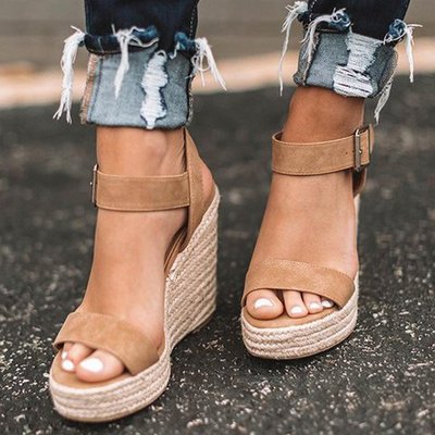 Women tan wedge sandals with espadrille sole and buckled ankle strap front view paired with jeans