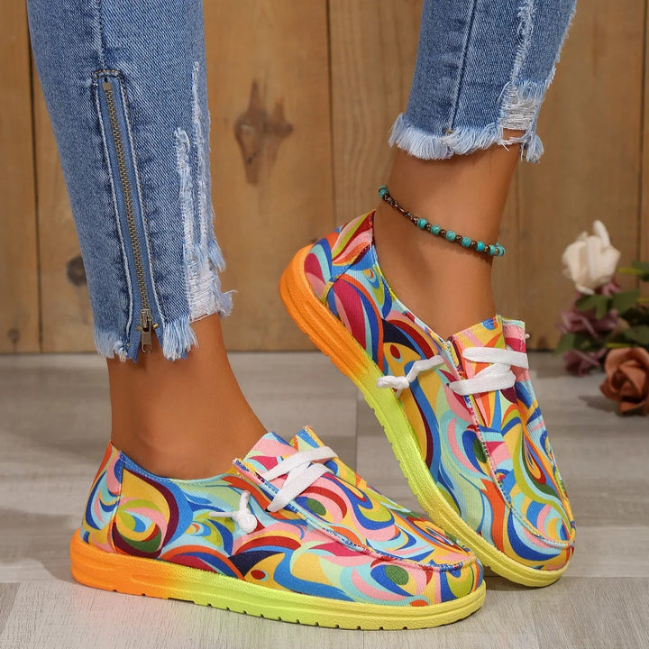 Women multicolor abstract printed low top sneakers with white laces and a gradient sole.