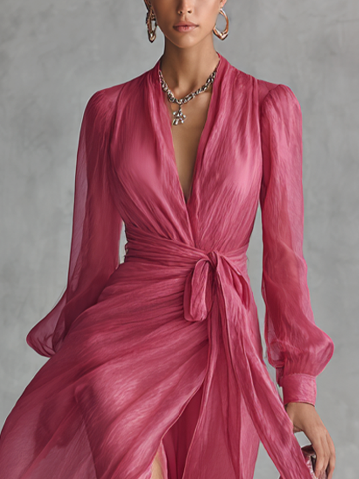 Close-up of pink V-neck tie-waist dress showing fabric texture and bishop sleeve details.