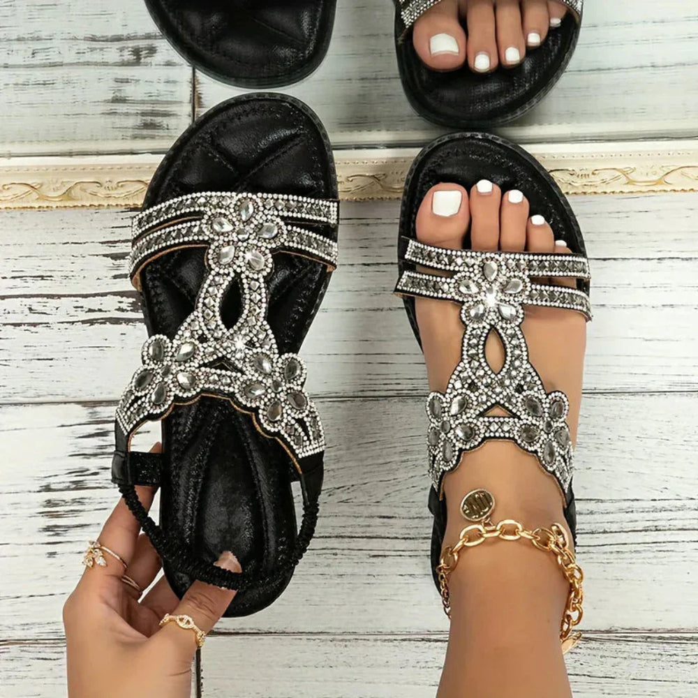 Women's black embellished flat sandals with clear sparkling straps shown from above