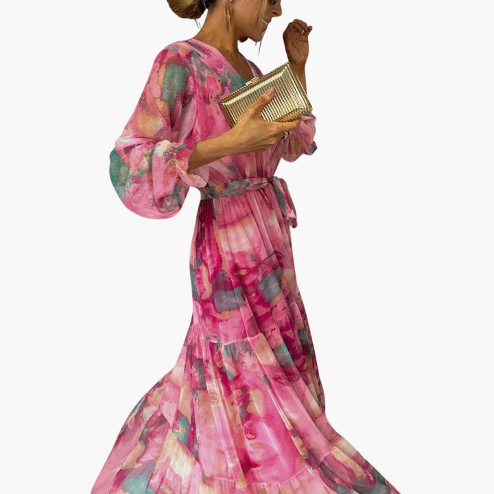 Women's pink floral long sleeve maxi dress showcasing flowing tiered skirt, side view