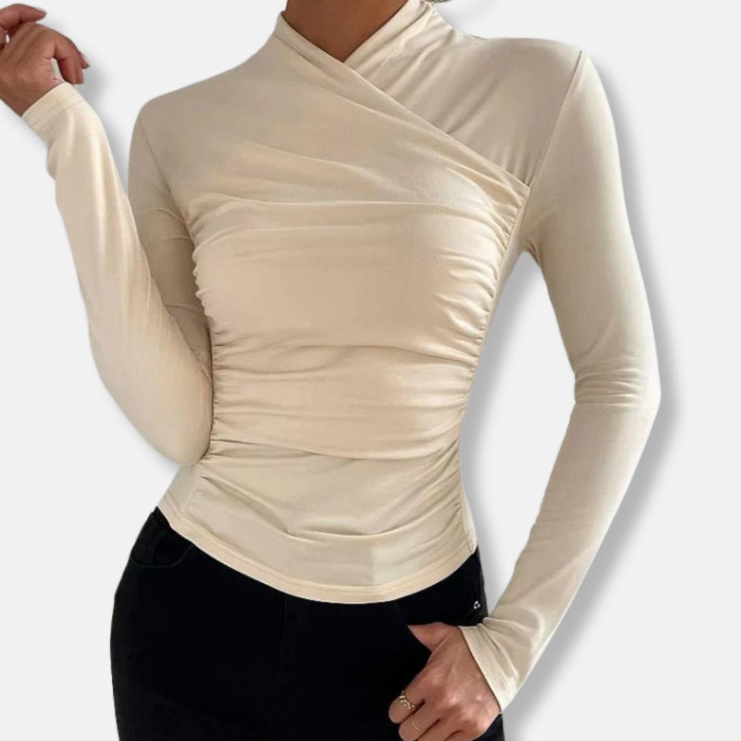 Women beige long sleeve cross neck top with ruched side detail worn with dark pants and hand in pocket