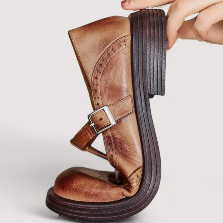 Side profile of a brown casual buckle Mary Jane shoe being bent to show flexible sole