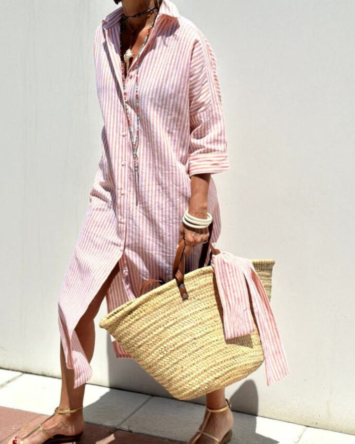 Women striped pink and white maxi shirt dress with long sleeves and side slit, front view.