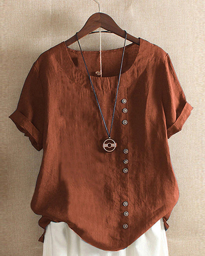 Women brown short sleeve blouse with cuffed sleeves and round neck detail on wooden hanger