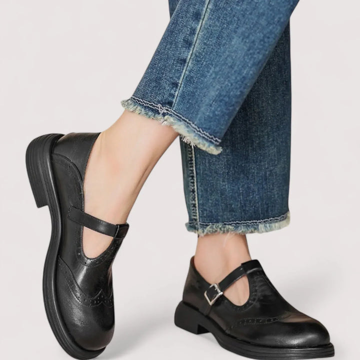 Women black casual buckle Mary Jane shoes on feet with frayed hem jeans