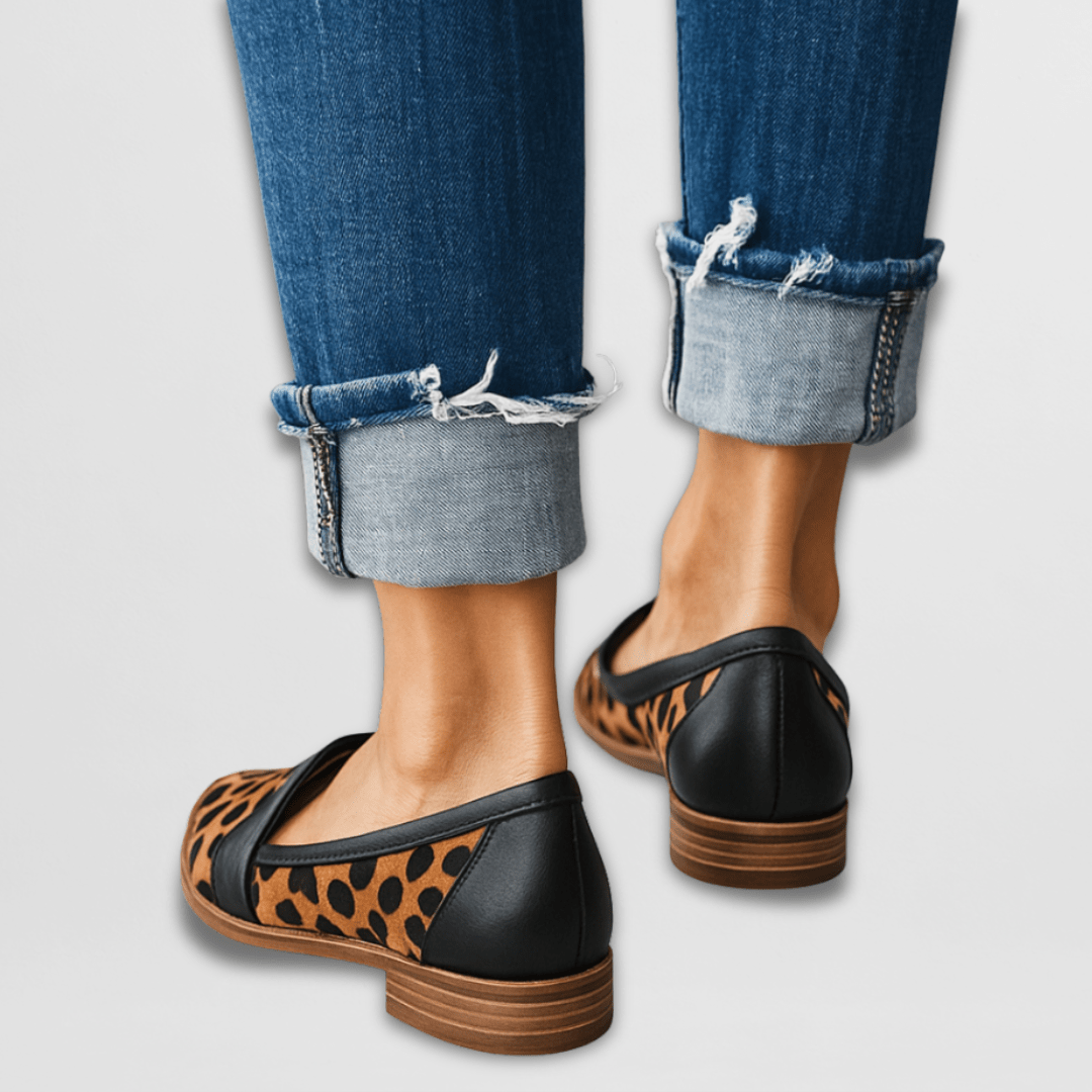 Women leopard print pointed toe loafers with black heel worn with blue cuffed jeans, back view