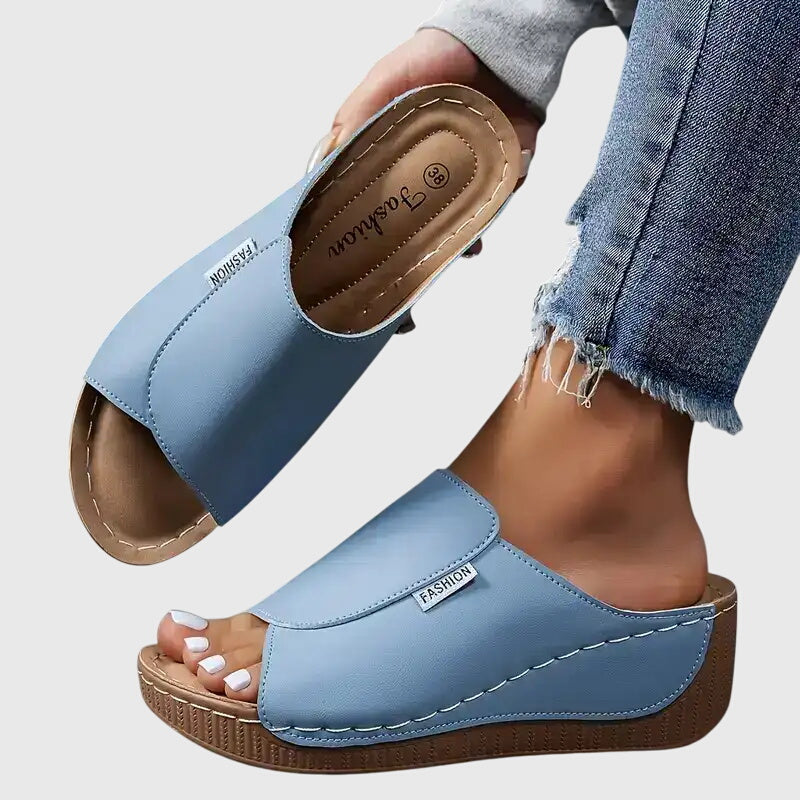 Women light blue open toe wedge sandals with wide strap and visible stitching on sole.