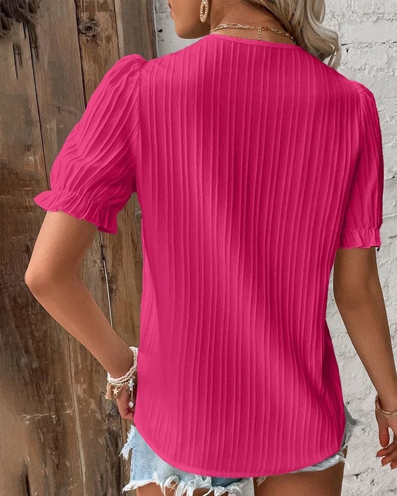 Women hot pink lace V neck blouse back view showing textured fabric and puff sleeves.