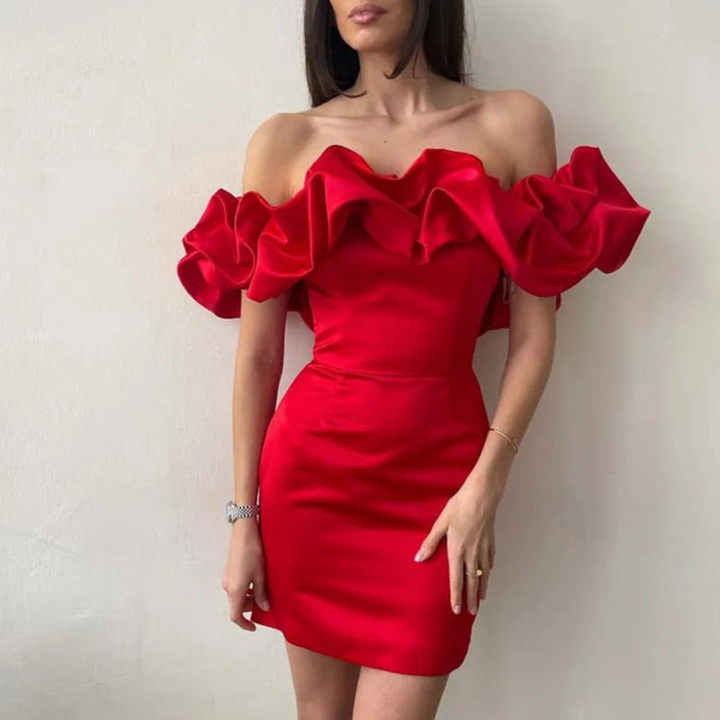 Women red off-shoulder mini dress with ruffled sleeves and fitted waist in front of a wall