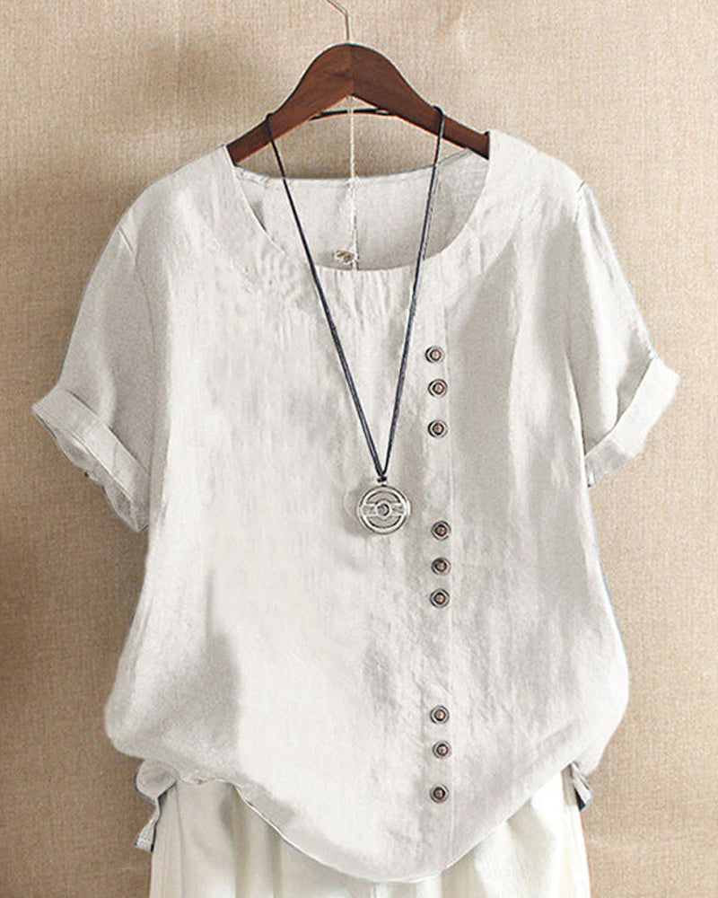 Women white short sleeve blouse with round neckline and decorative side buttons displayed on hanger