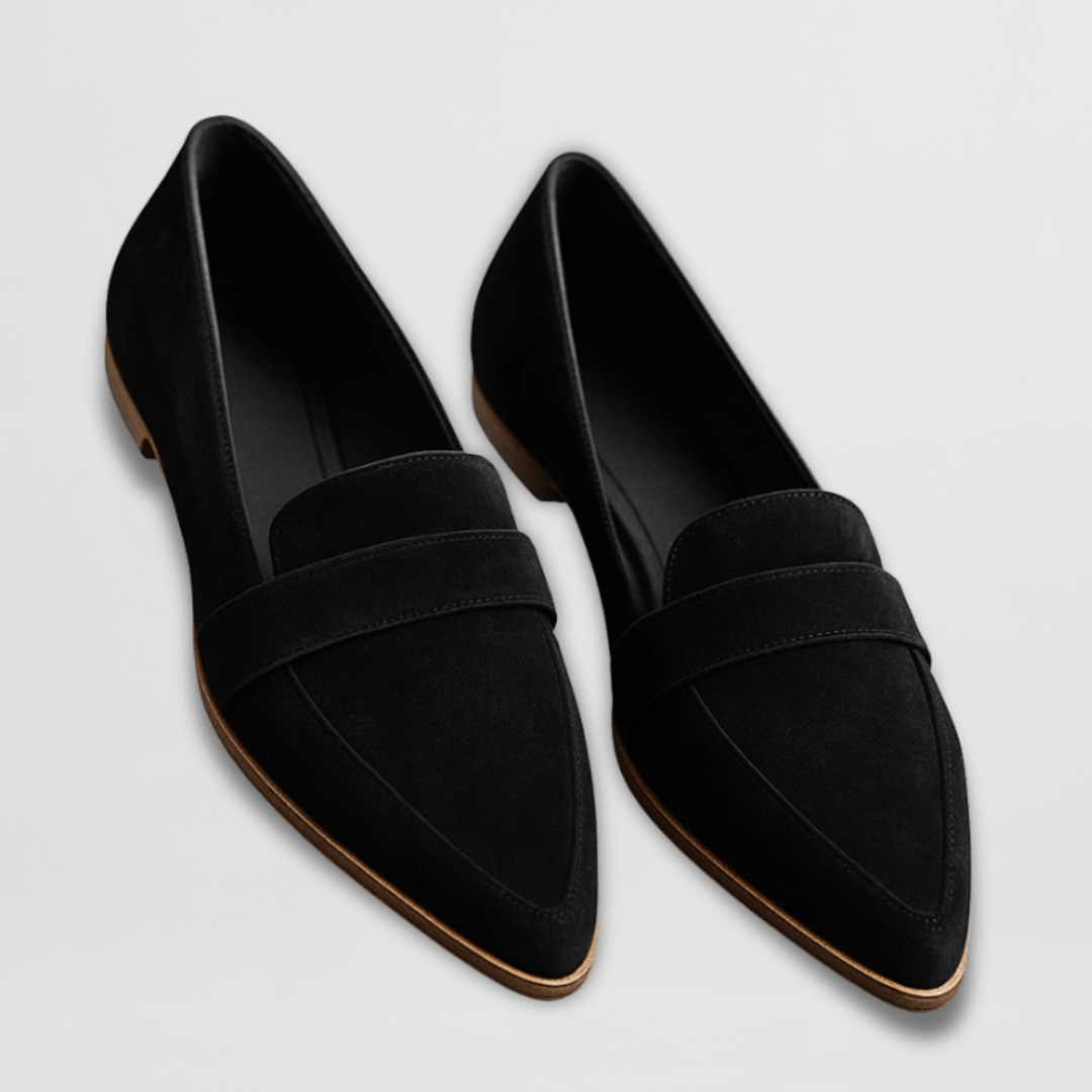 Pair of black suede pointed toe loafers with light brown sole, overhead view