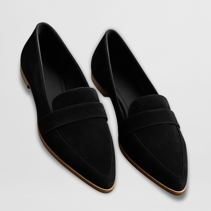 Pair of black suede pointed toe loafers with light brown sole, overhead view
