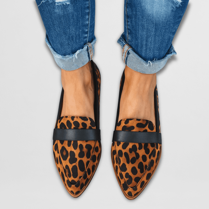 Women leopard print pointed toe loafers with black band worn with blue cuffed jeans