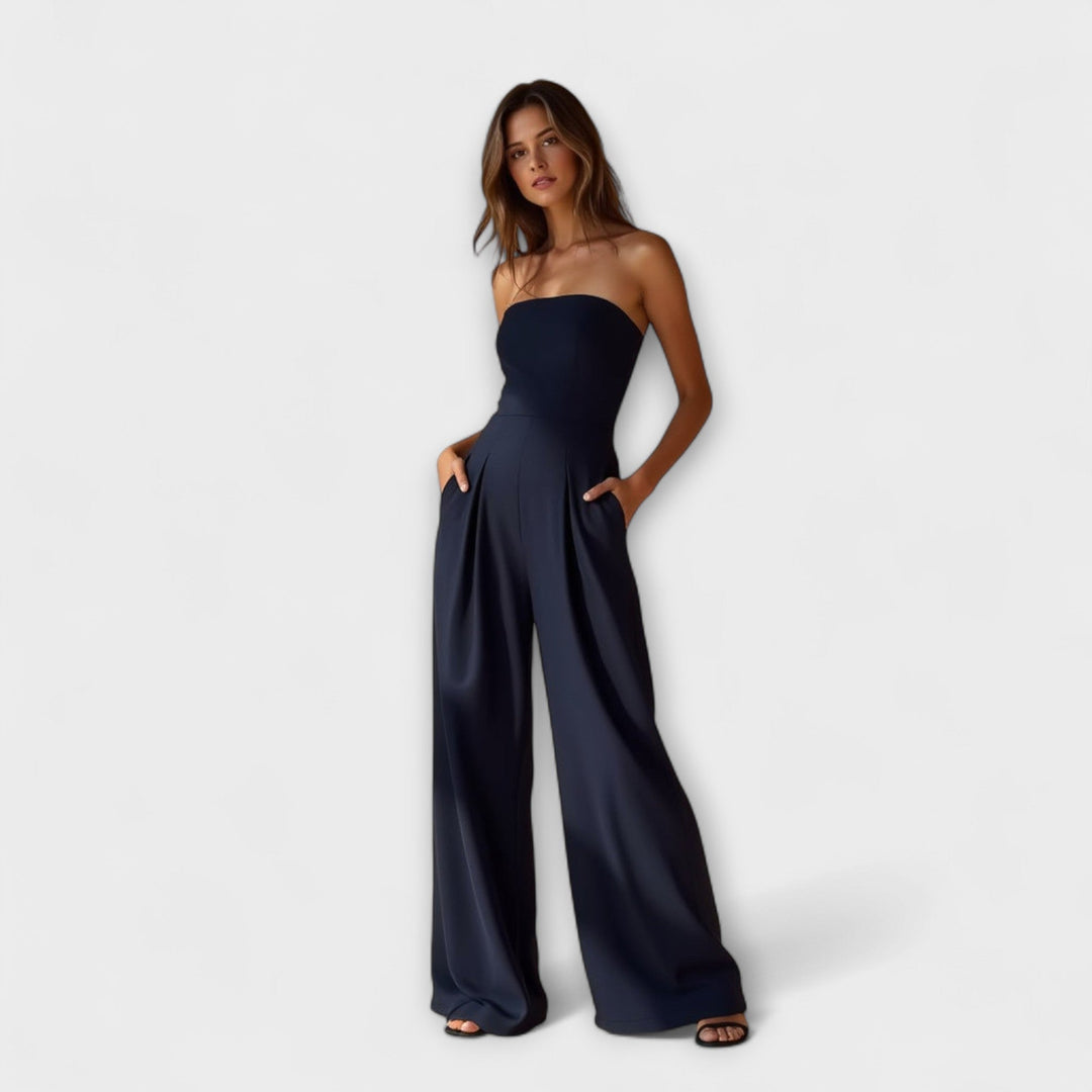 Women navy strapless wide leg jumpsuit with side pockets and structured pleats, full body view