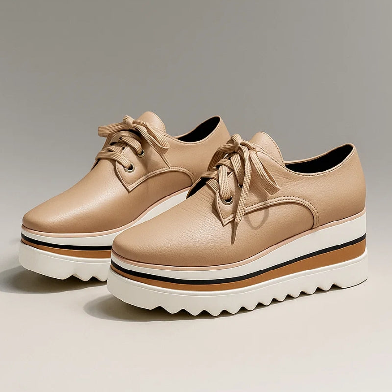 Pair of women beige lace-up platform wedge sneakers with layered soles on a gray background