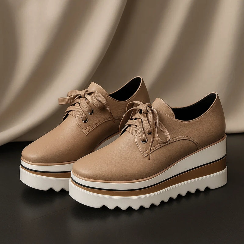 Pair of women beige platform wedge sneakers with chunky layered sole against a draped curtain