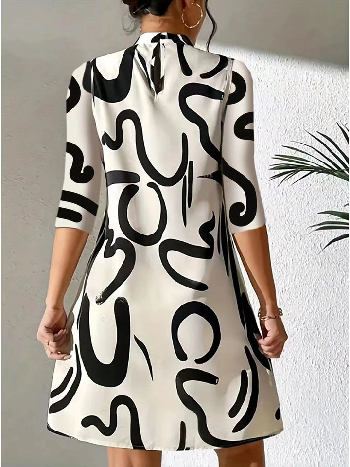 Women white and black printed mini dress, back view showing keyhole detail and pattern.