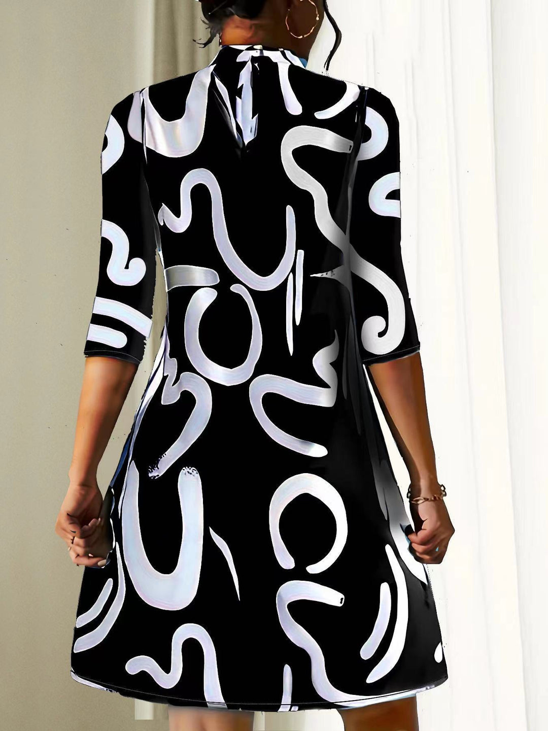 Women black and white printed mini dress with 3/4 sleeves, back keyhole closure visible.