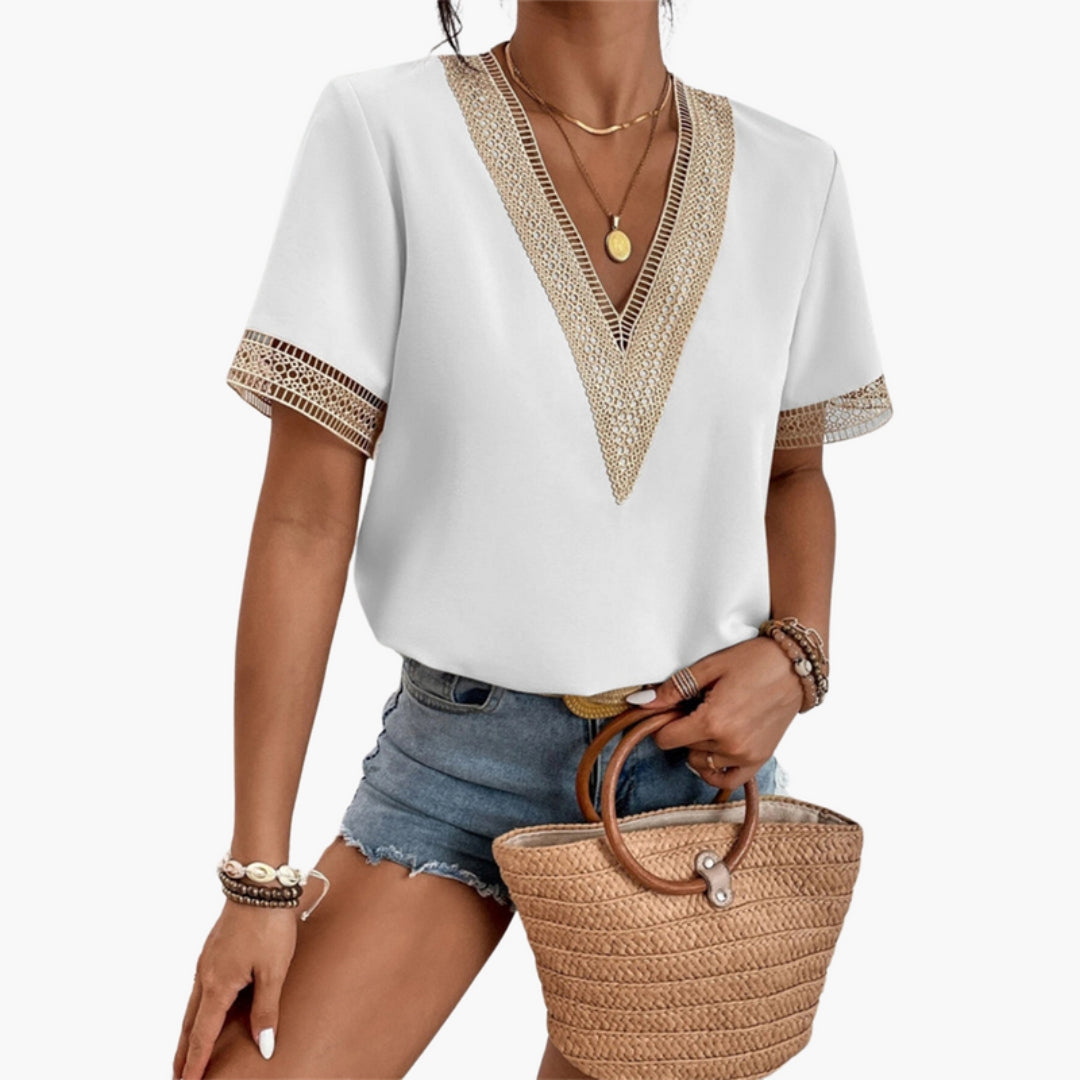 Women's white V-neck short sleeve blouse with lace trim detailing on neckline and short sleeves.