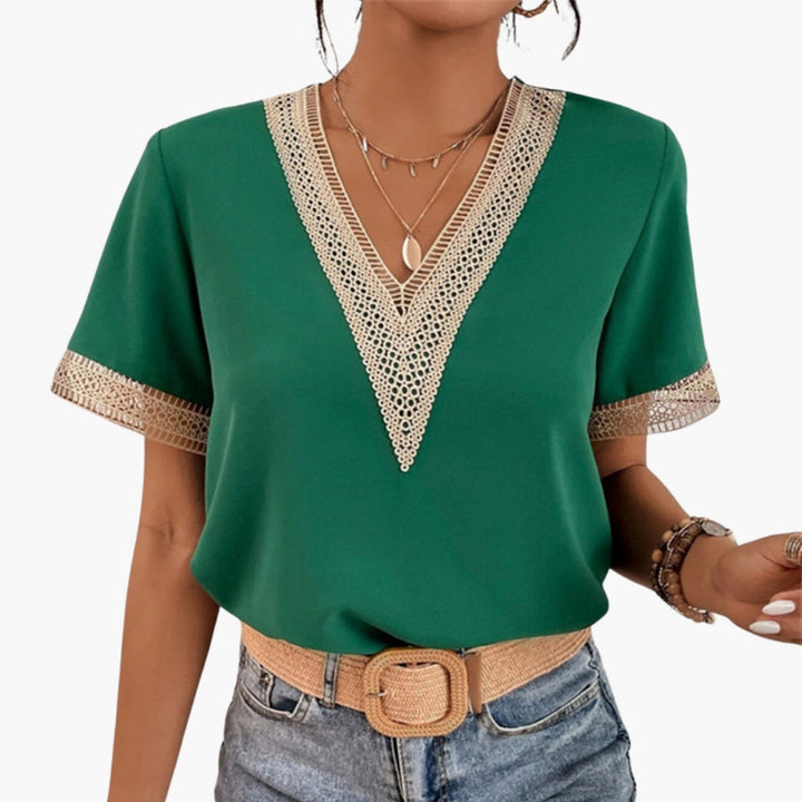 Women's green V-neck short sleeve blouse with decorative lace trim details around the neckline and cuffs.