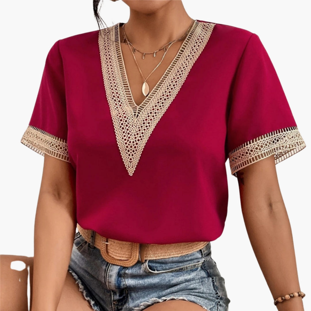Women's red V-neck short sleeve blouse with a wide lace trim at the neck and along the sleeve edges.