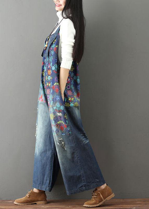 Women blue floral printed wide leg denim jumpsuit, side view with hands in pockets
