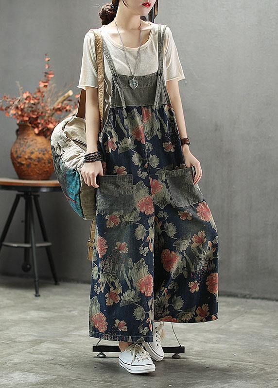 Women's dark blue floral printed midi denim romper with front patch pockets and adjustable straps, front view.