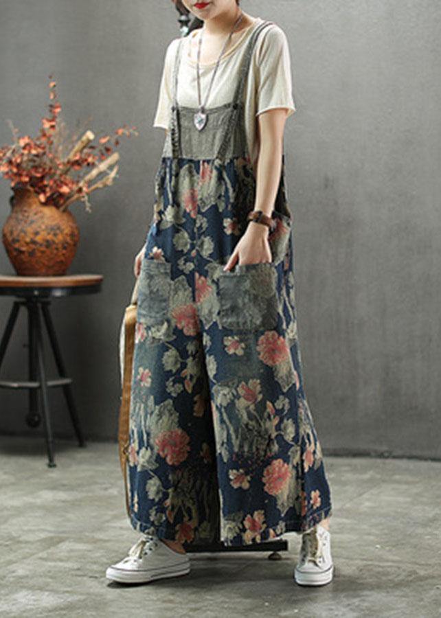Women's dark blue floral printed midi denim romper with front patch pockets visible, side angled view.