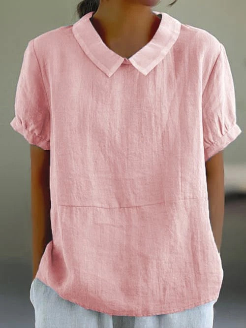 Women pink short sleeve casual blouse with rounded collar and textured cotton fabric on model