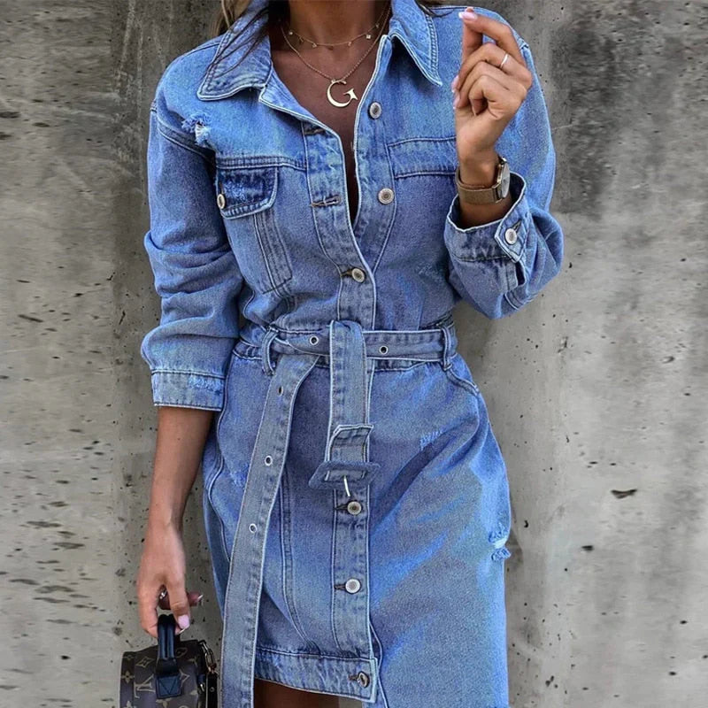 Women's blue denim mini dress with button closure, collared neckline, and belt detail