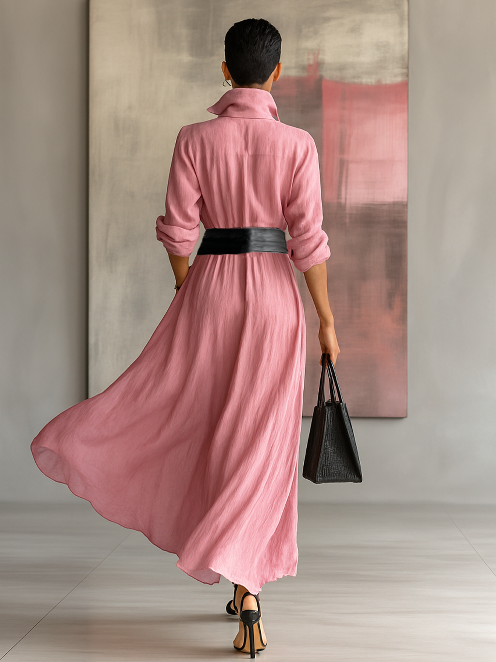 Women's pink collared maxi shirt dress with black belt in a back view, showing button placket