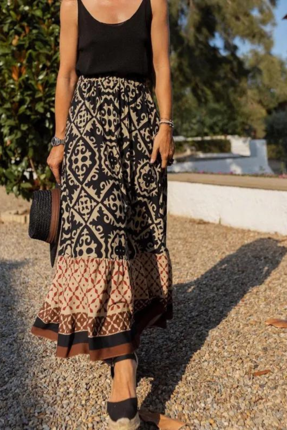 Women black beige printed A line maxi skirt with tiered hem, walking view, outdoors