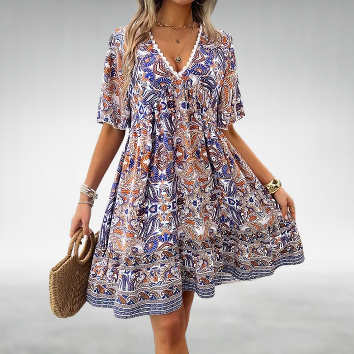 Women blue and orange paisley print mini dress with V-neckline, short sleeves, and flowing skirt.