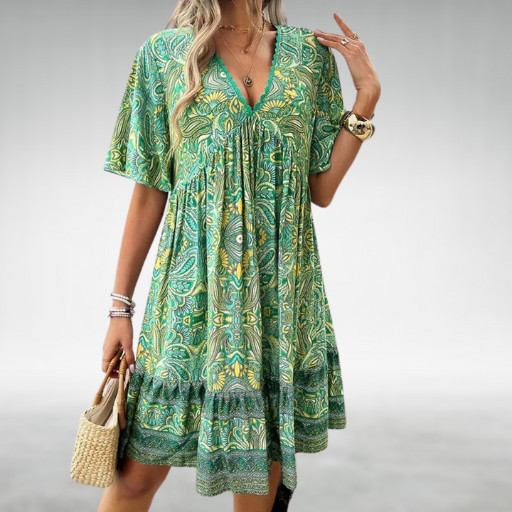 Women green paisley print mini dress with V-neckline, short sleeves, and tiered hem, front view.