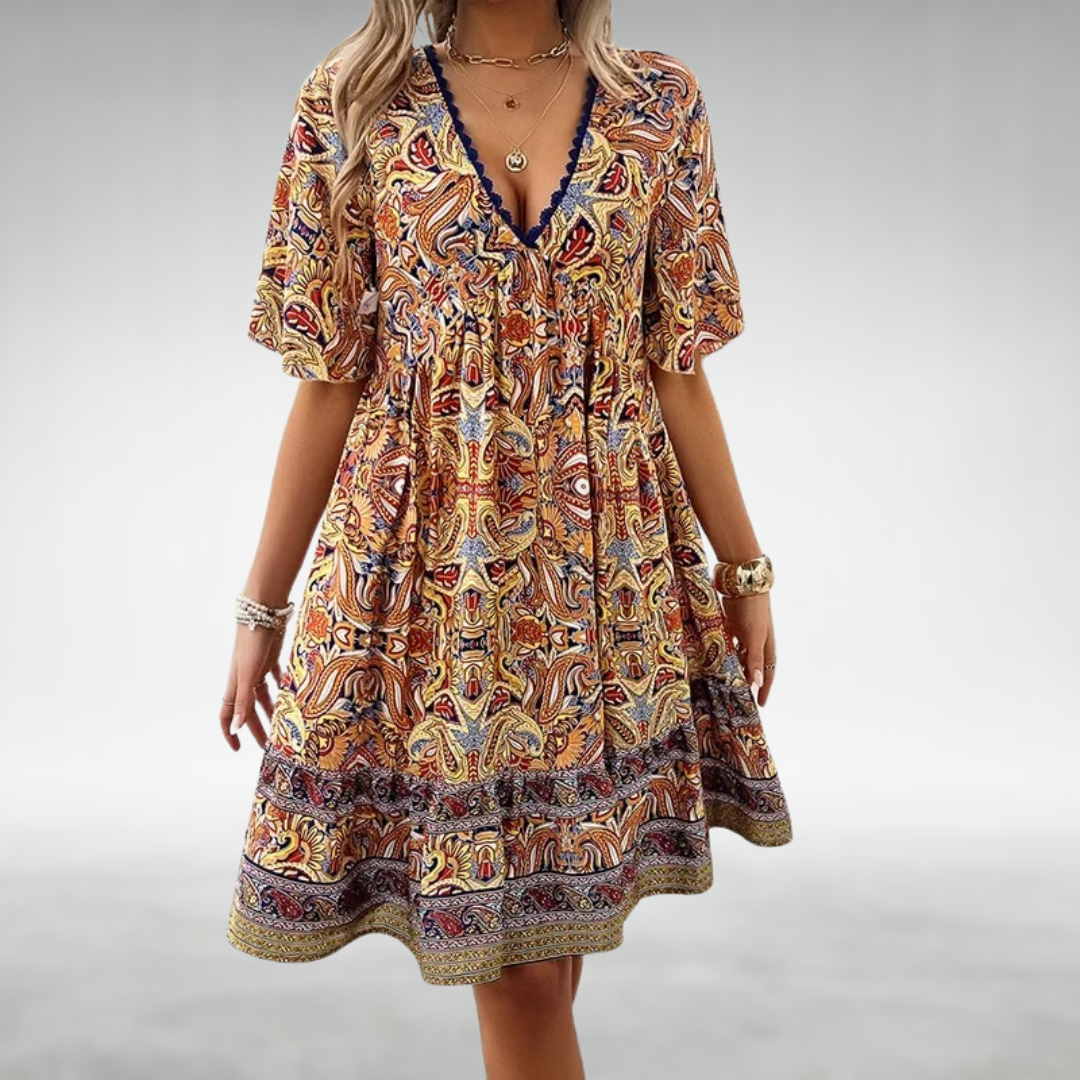 Women yellow and orange paisley print mini dress with V-neckline and tiered ruffle hem detail.
