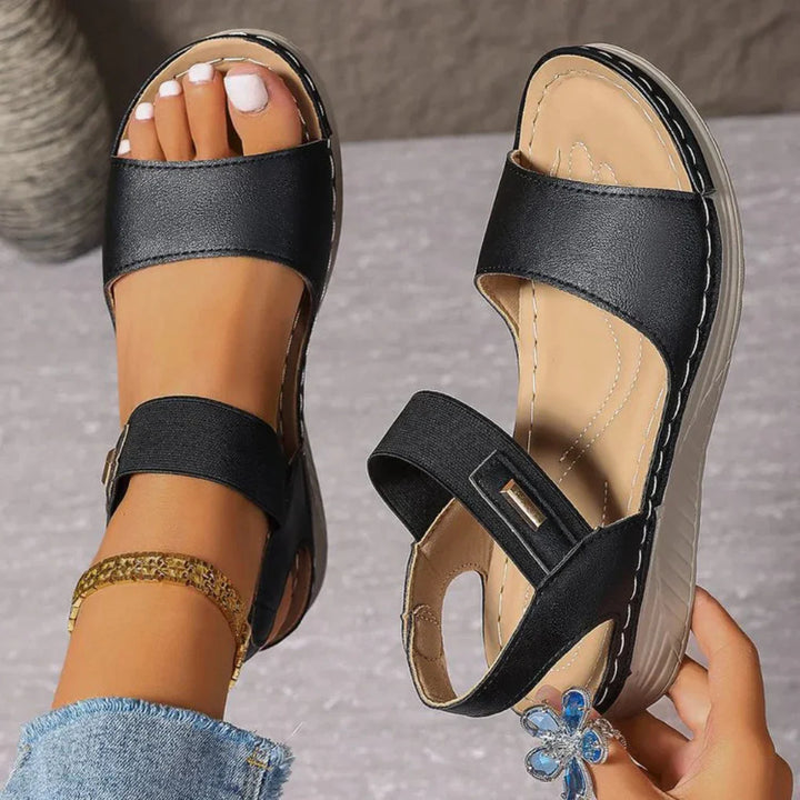 Women black two-strap adjustable sandals with open toe and cushioned sole, side view