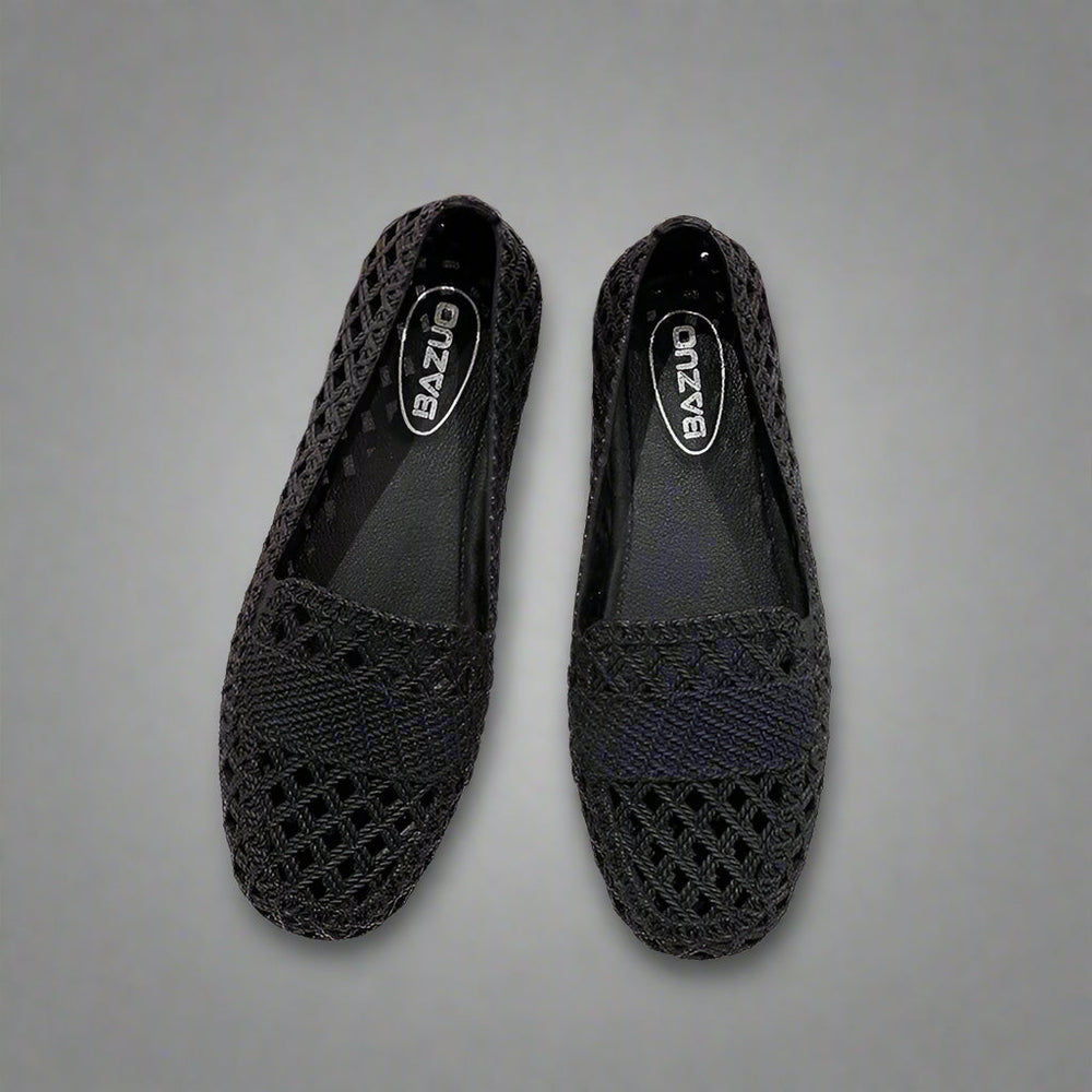 Women black woven knit slip-on flats with pointed toe and flat sole on a dark gray background.