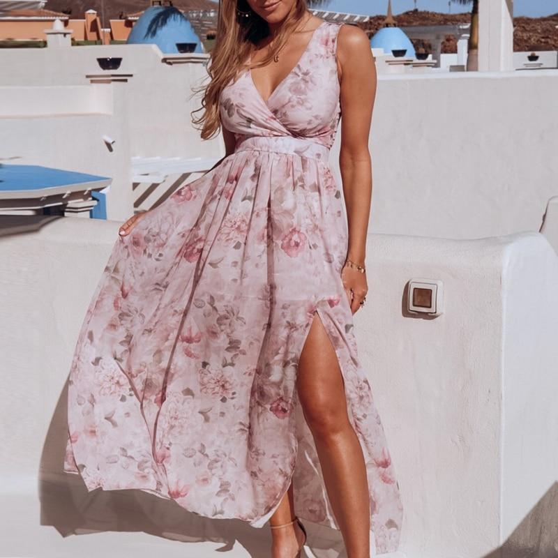 Women light pink floral maxi dress with wrap V-neck and sleeveless design, shown with side slit.