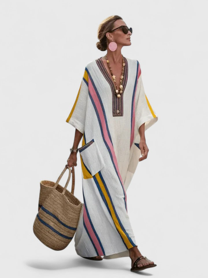 Women's multi-color striped V-neck maxi dress with three-quarter sleeves and large front pocket, walking stance.