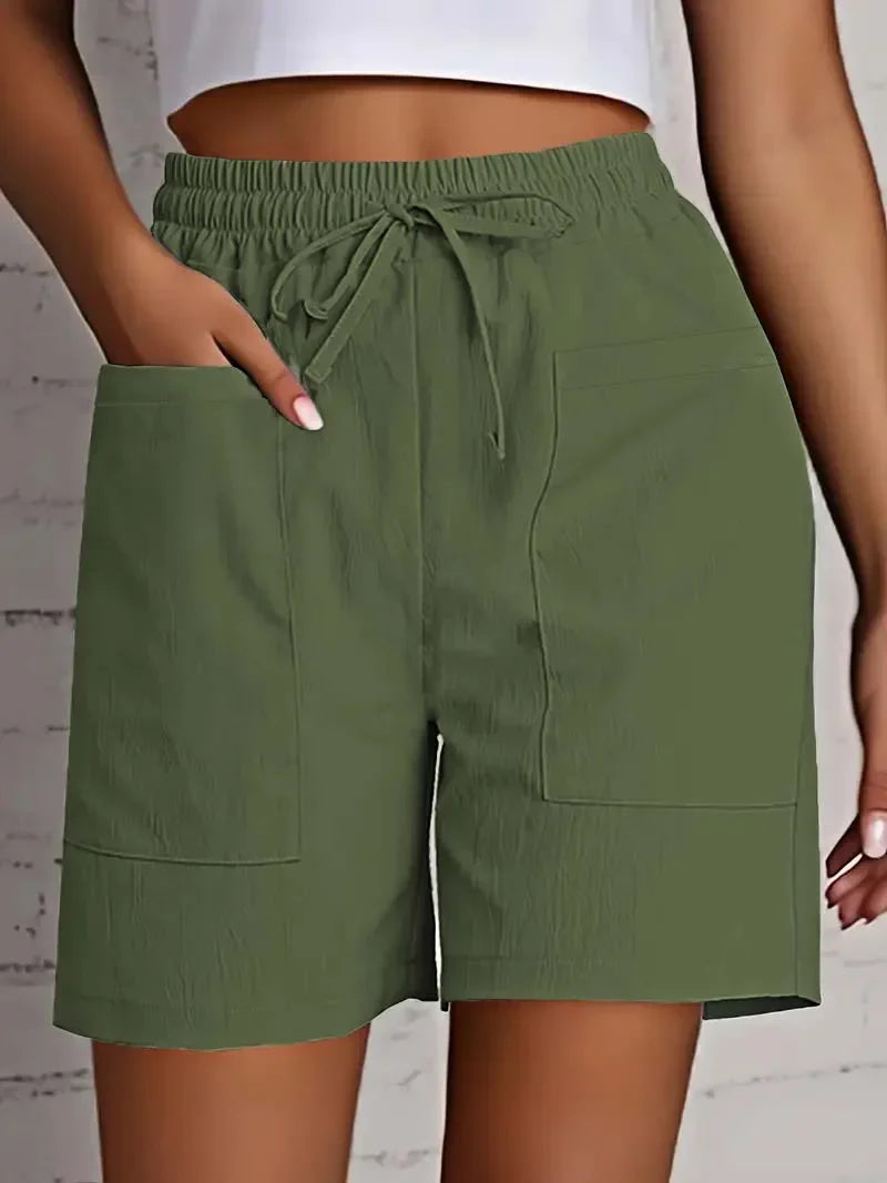 Women green casual shorts with elastic waist, drawstring details, and large front patch pockets, mid-thigh.