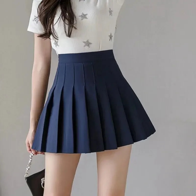 Women navy blue high waist pleated mini skirt, front view, paired with a white star-print top.