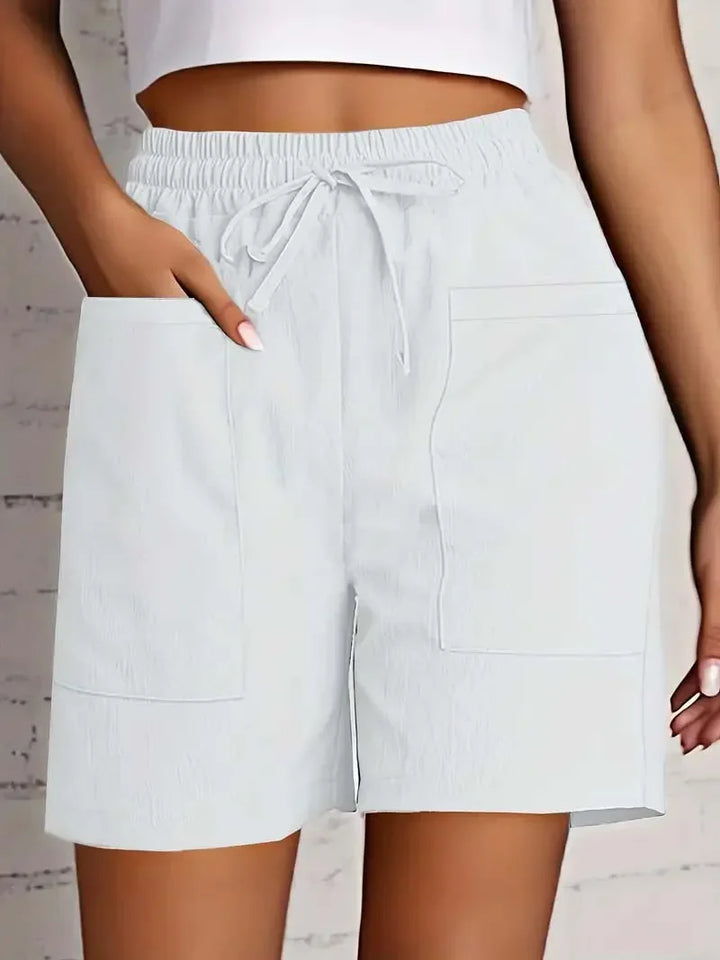 Women white casual shorts with elasticated waist and adjustable drawstring, showing front patch pockets.